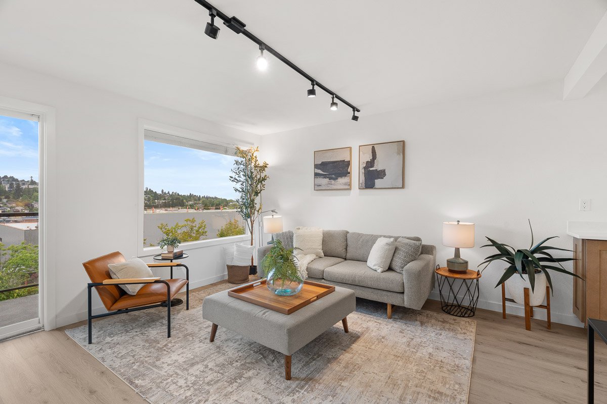 Professional real estate photography of a bright Seattle living room with large windows, modern furnishings, and natural light.
