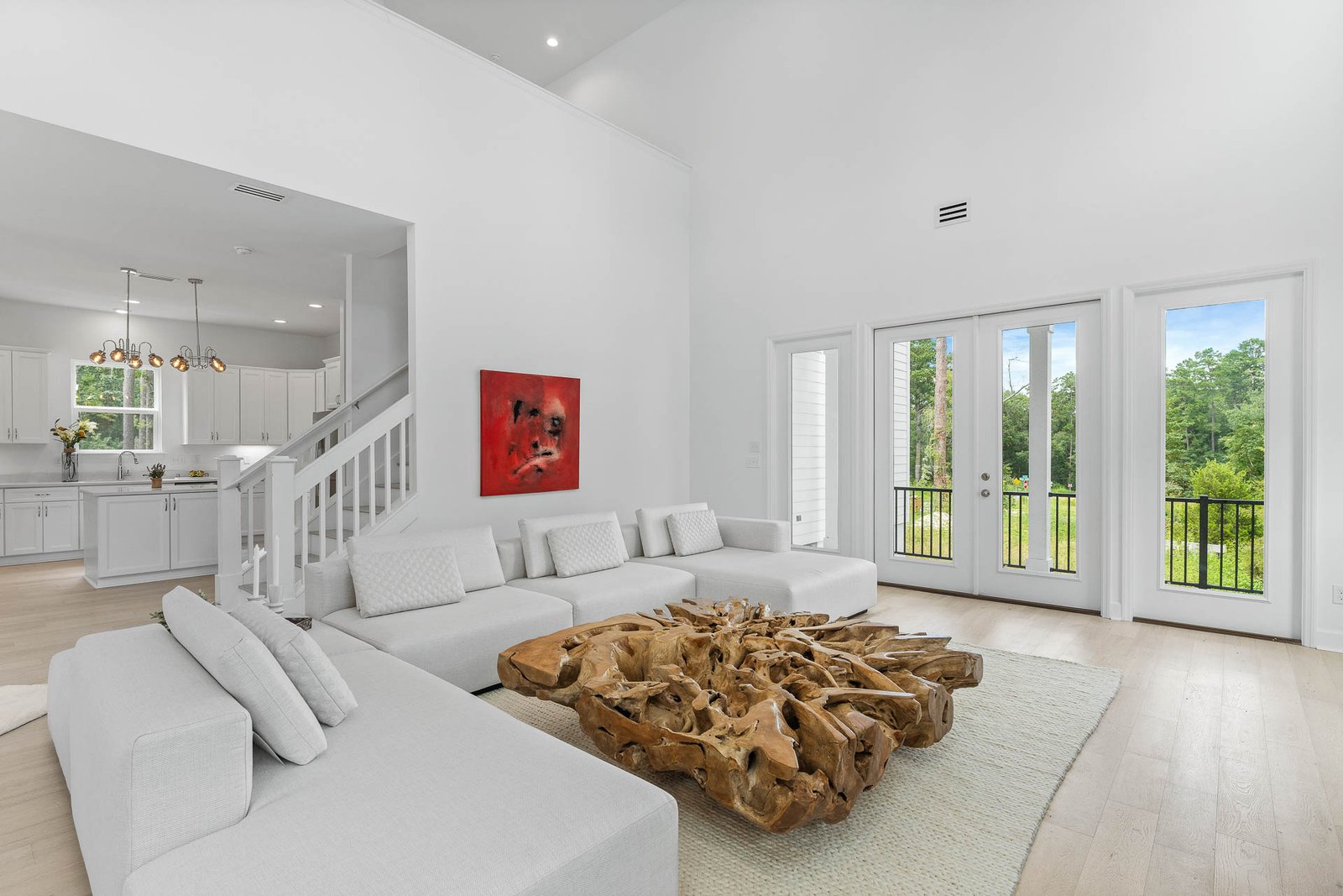 Professional real estate photography of a bright Seattle living room with soaring ceilings, modern staging, large windows, and an open-concept layout.