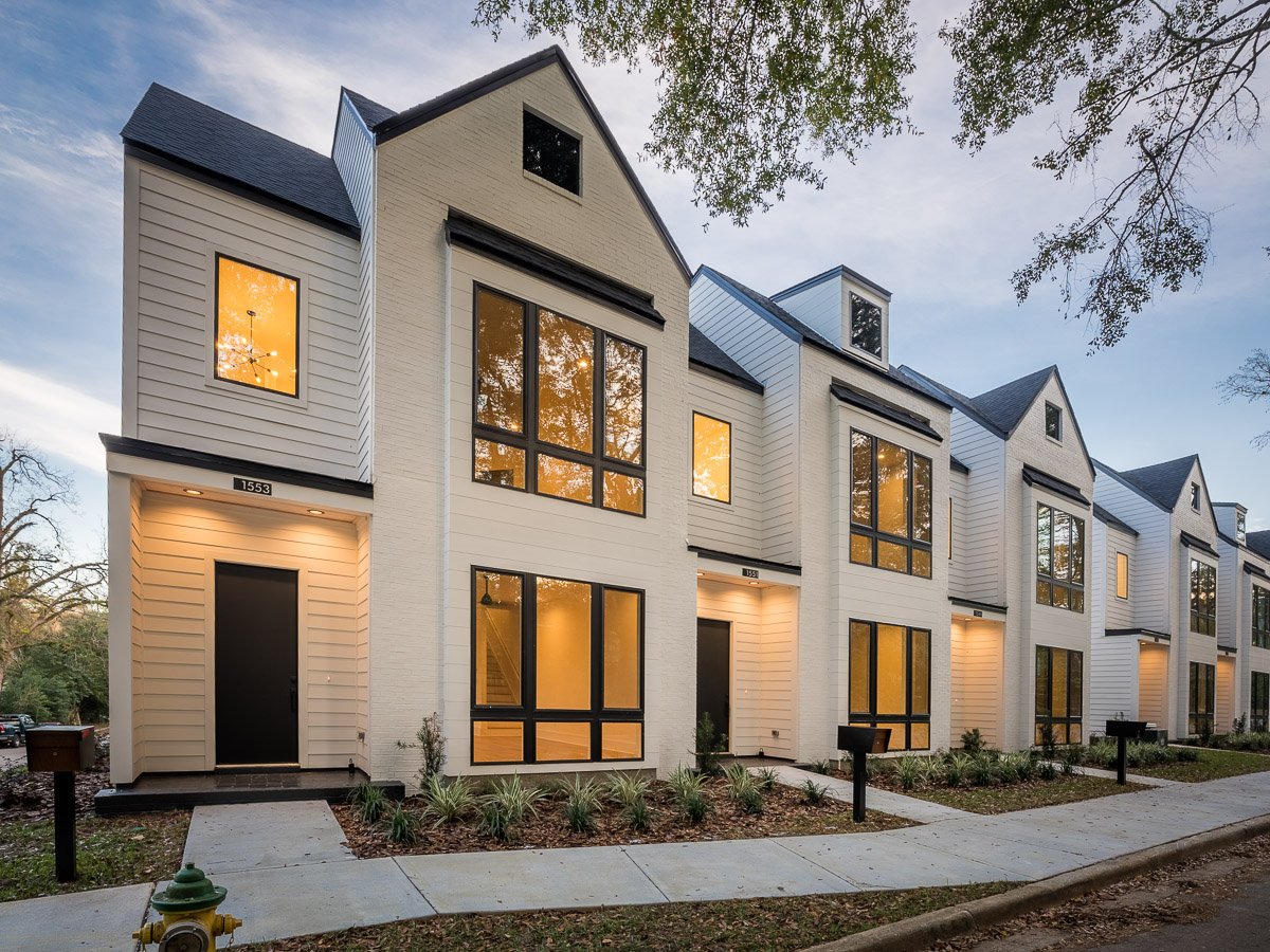 Professional real estate photography of modern Seattle townhomes at dusk with warm interior lighting, contemporary architecture, landscaped entries, and strong curb appeal.